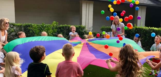 Action shot of a child jumping over a large puddle, practicing motor planning and judging distances in nature.