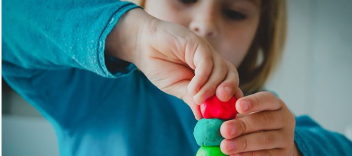 Children wearing rain boots splashing in puddles, showing that beneficial outdoor play can happen in wet weather.