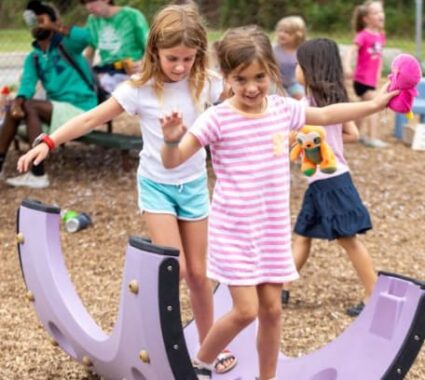 Parent and child walking hand-in-hand on a dirt path, enjoying connection and healthy physical movement outdoors.